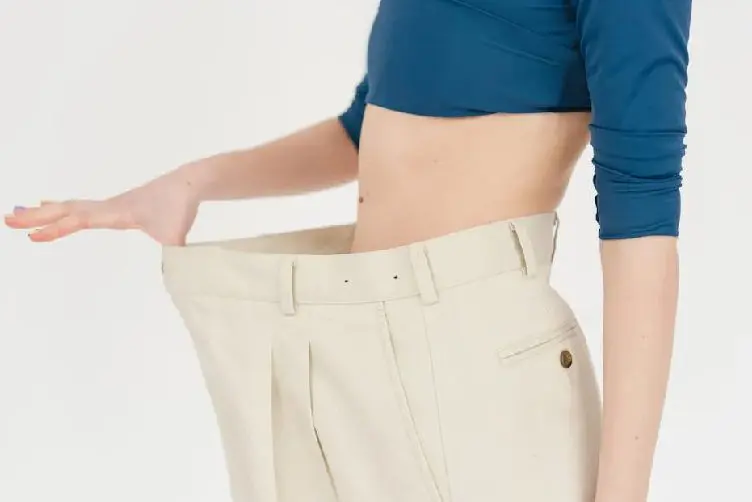 Person wearing oversized beige pants holding waistband