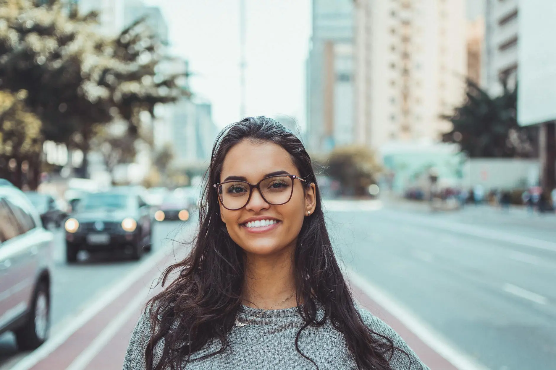 Smiling woman with glasses on city street
