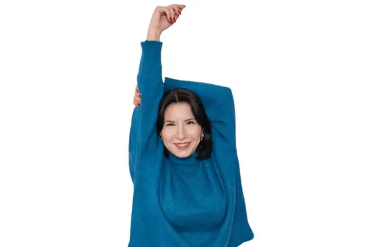Smiling woman in blue sweater stretching arms