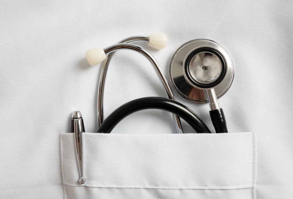 Stethoscope and pen in white coat pocket